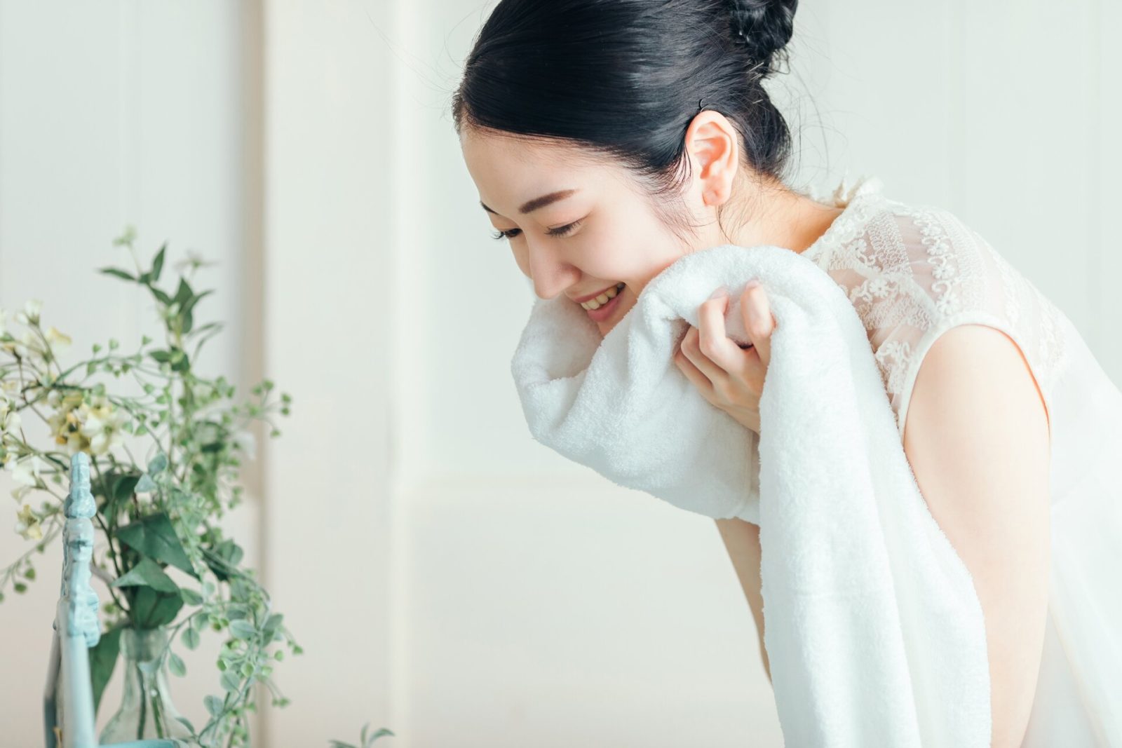 タオルで顔を拭く女性