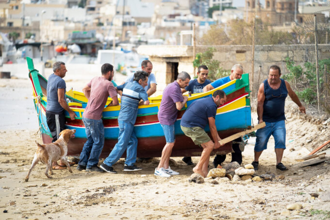 木造漁船を運ぶ実存の漁師たち