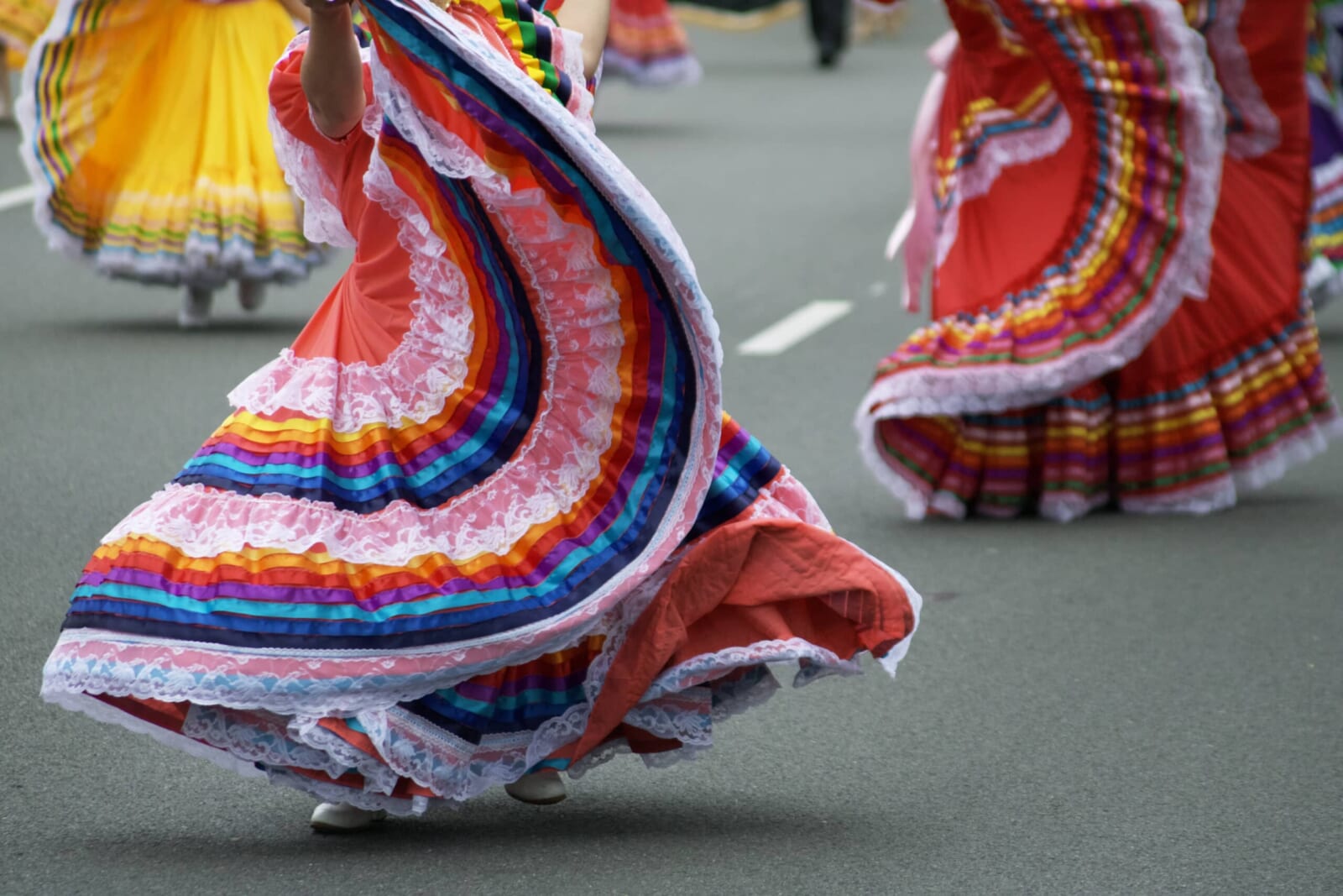レインボーカラーの民族衣装で踊る祭りの風景
