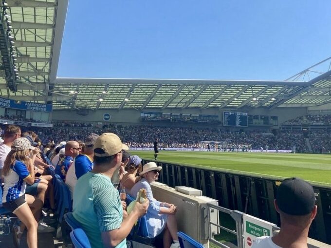 ブライトン＆ホーヴ・アルビオンFCのホームスタジアムでサッカーの試合を観戦する人々