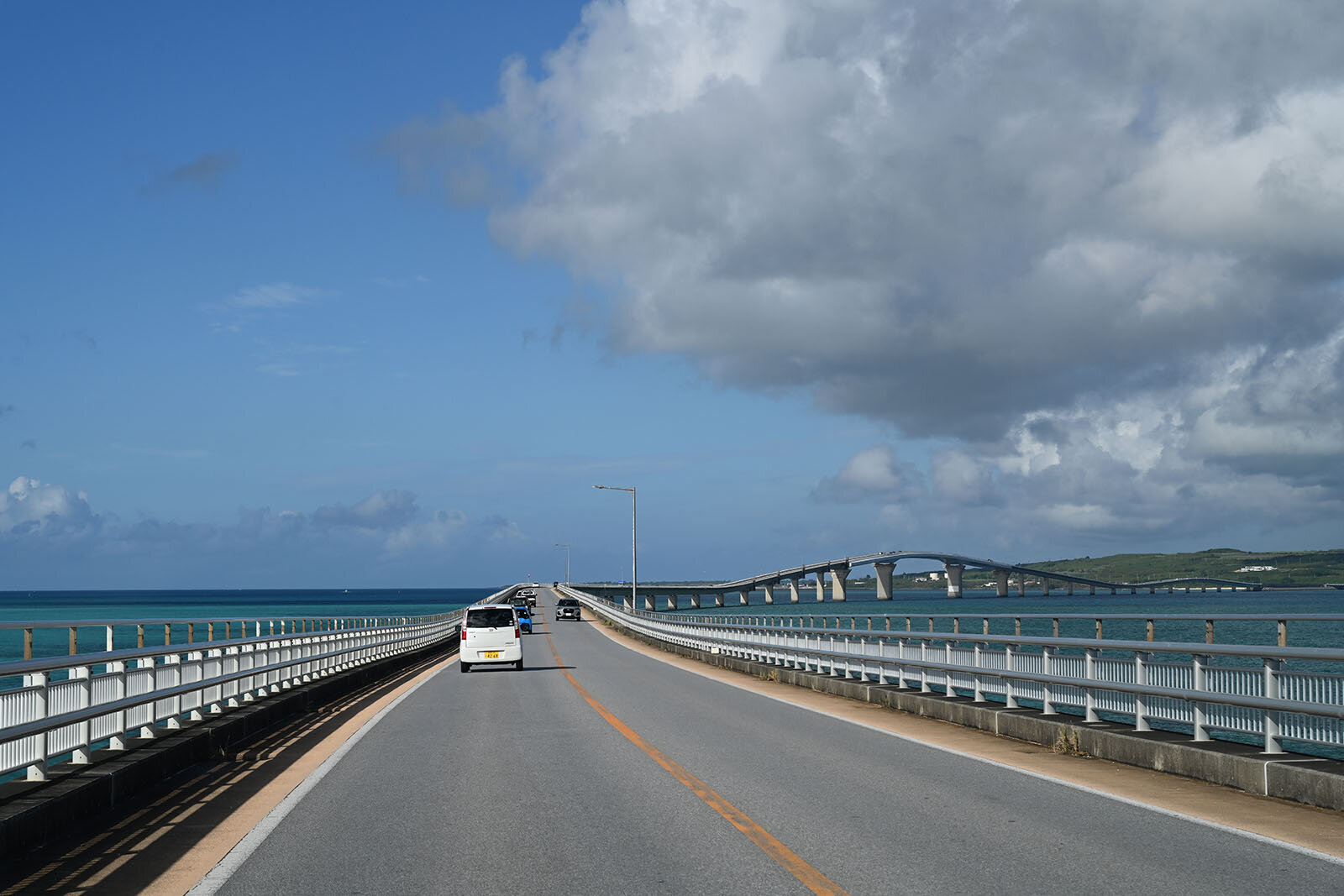 初めは平坦だが後半はアーチを描く大橋。その橋を車が数台走っている景色
