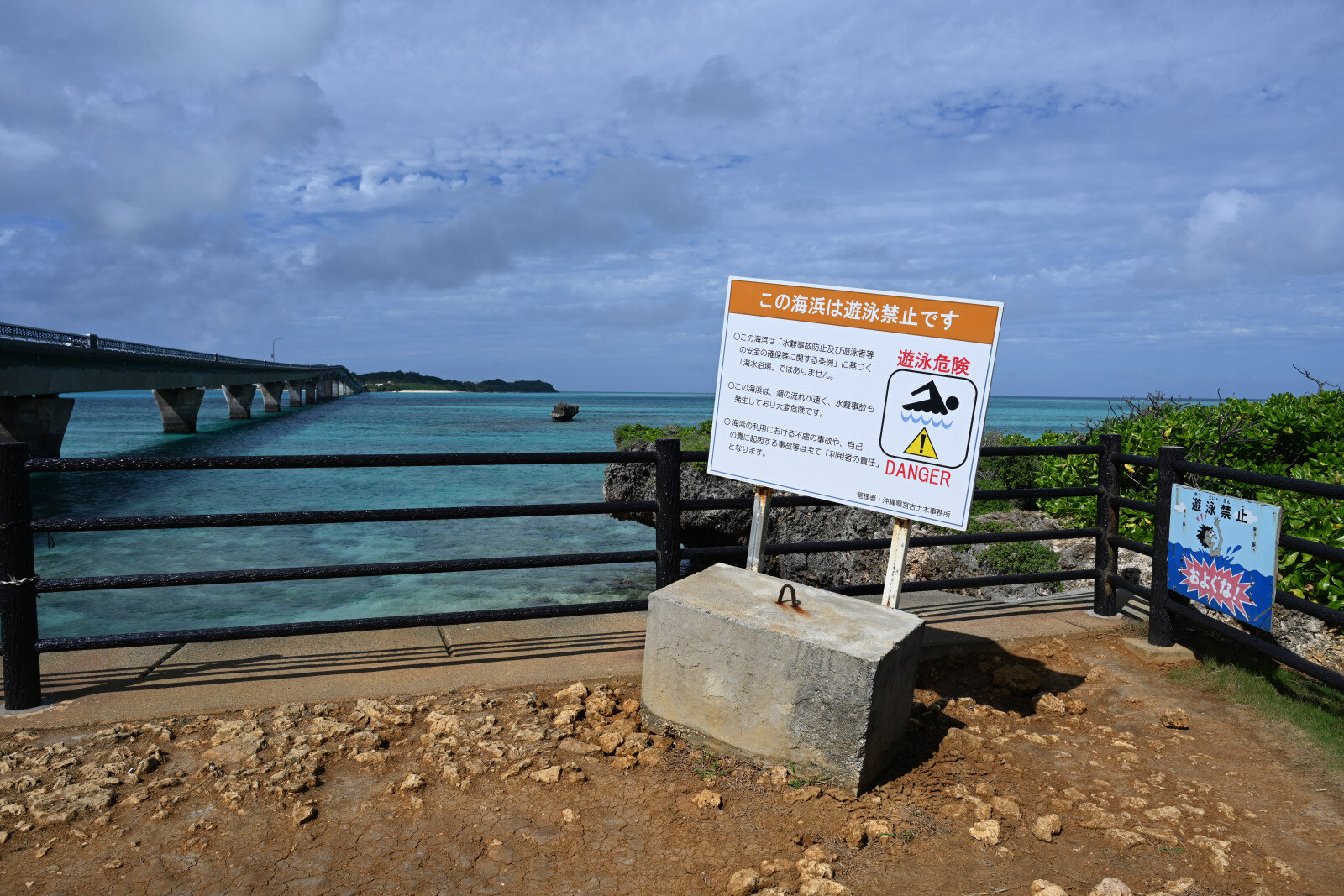 海浜沿いの柵の横に立てられた遊泳禁止の看板