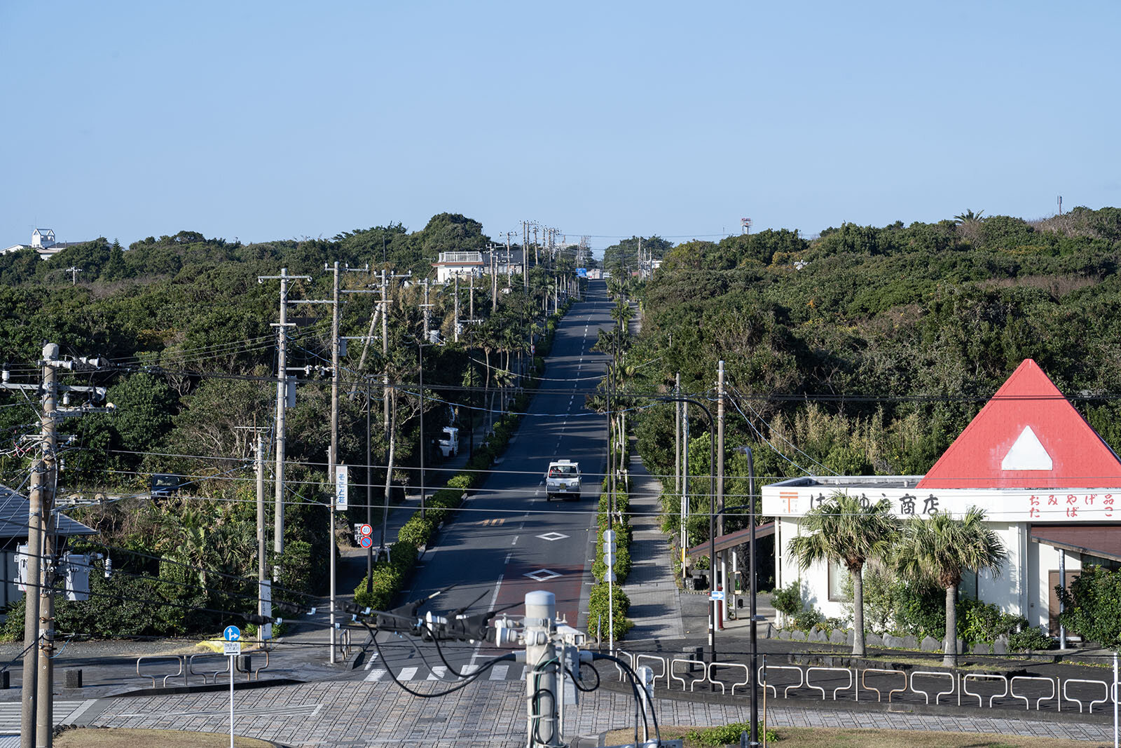 八丈一周道路と八丈中央道路の交差点には赤い屋根の商店がたつ