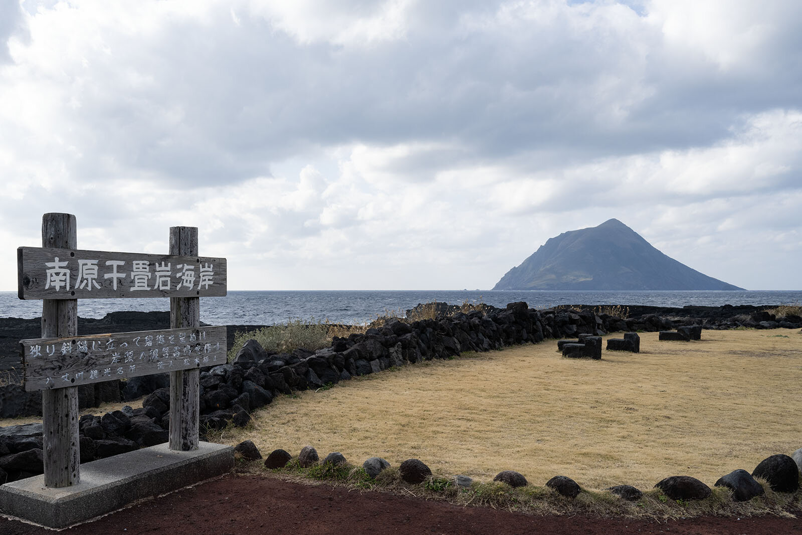 南原千畳岩海岸の看板と、奥に見える八丈小島