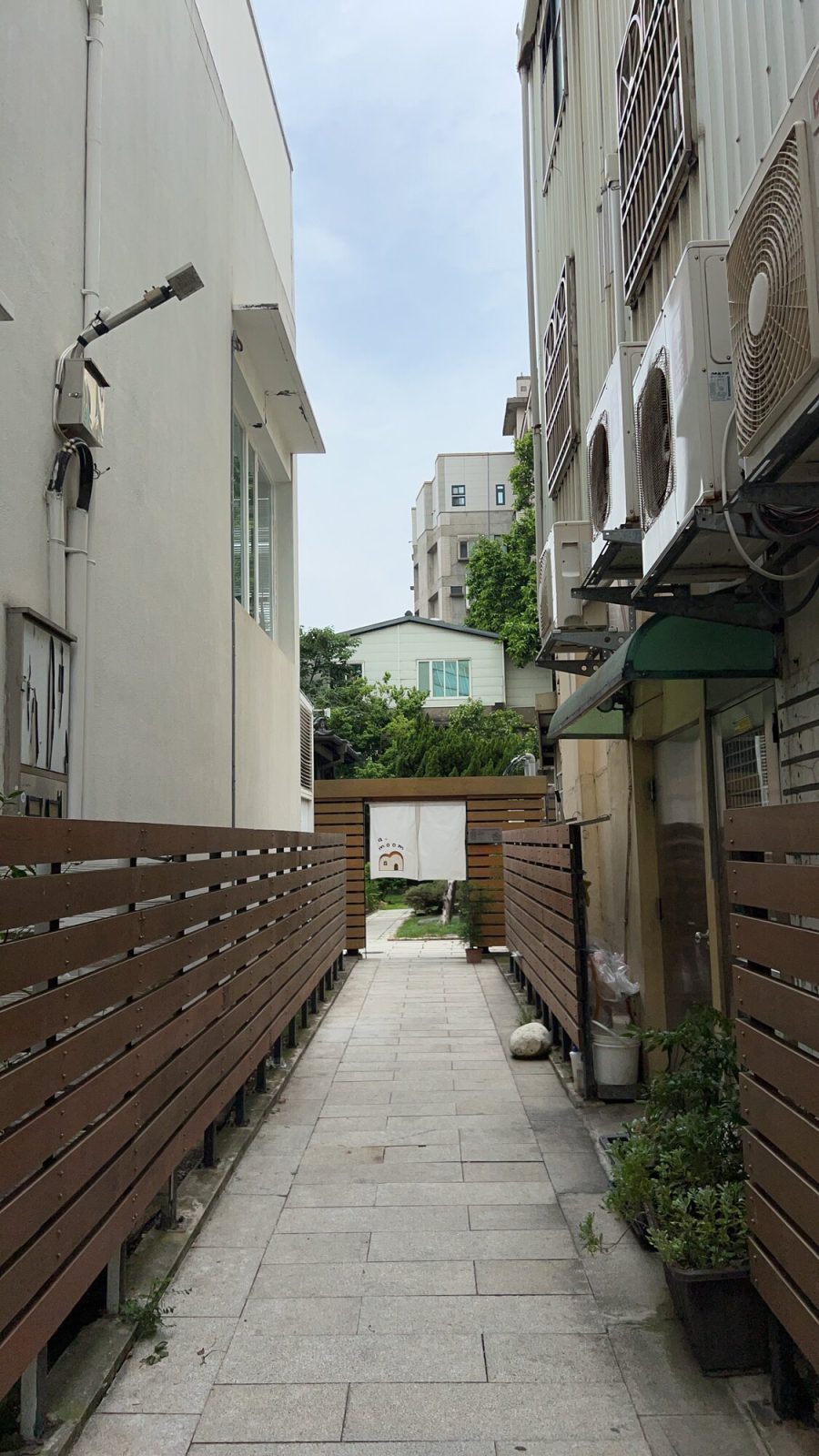 路地の奥に見える白い暖簾の入り口