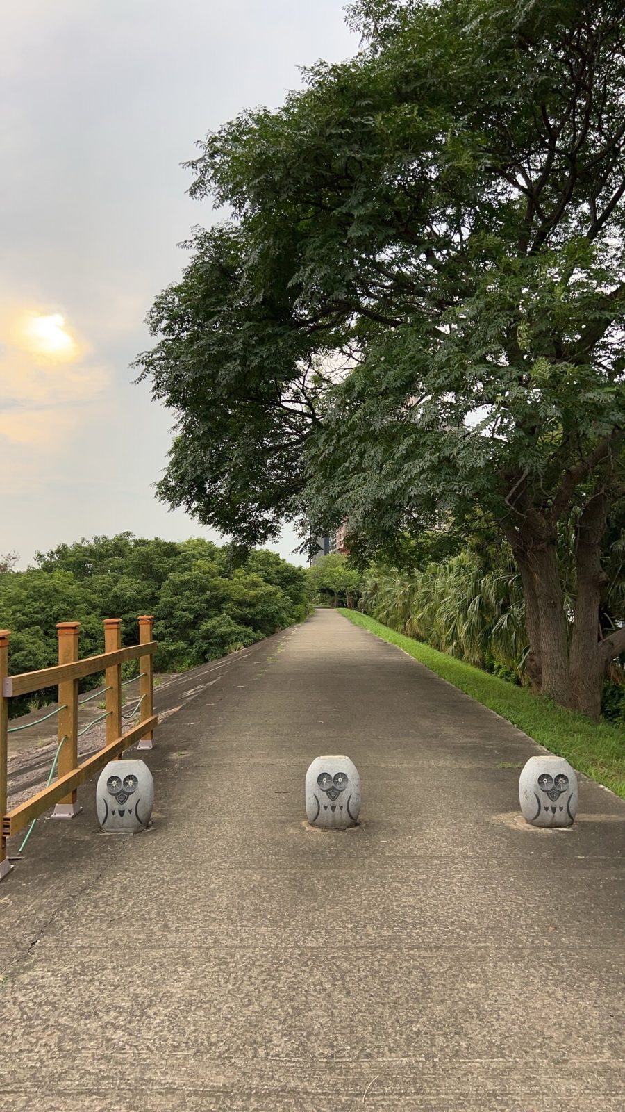 ふくろう模様の石柱が並ぶ木陰の堤防