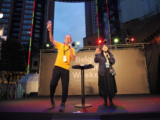 ベルギービールウィークエンド六本木のステージでビールグラスを掲げる男女