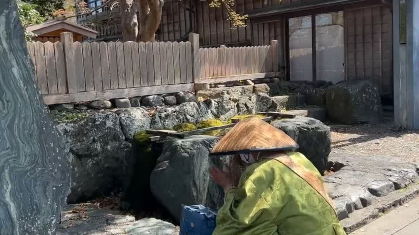 着物姿で庭泉に祈る人