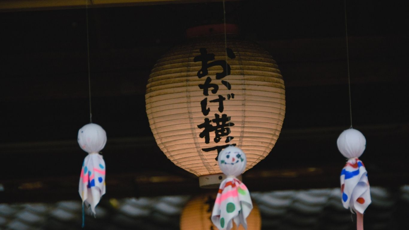 軒先に吊るされたおかげ横丁の提灯とてるてる坊主