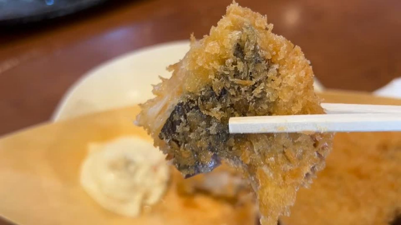 箸でつまむアジフライ