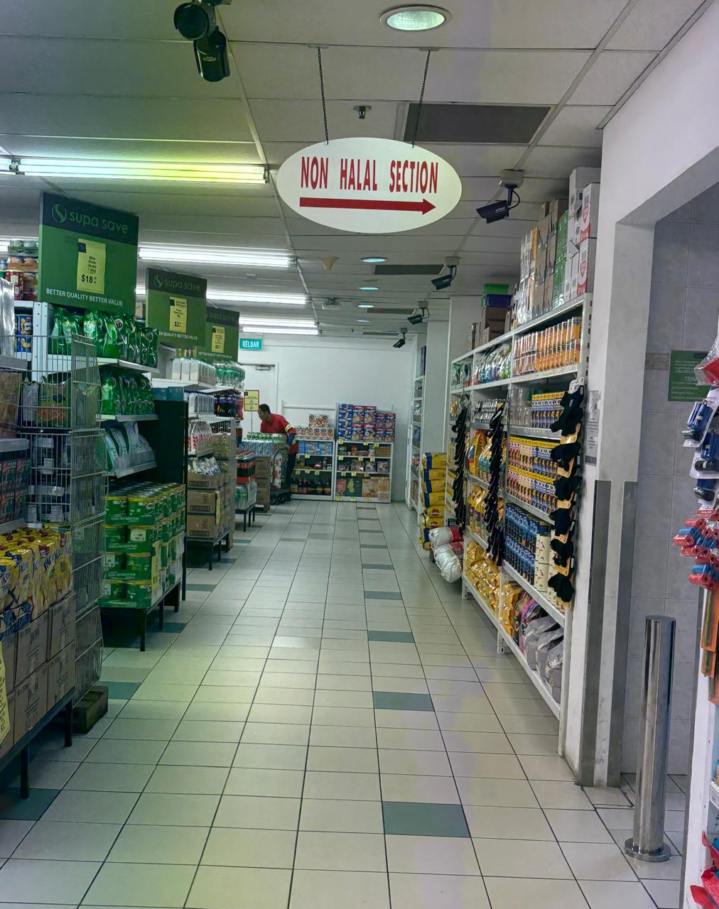 「NON HALAL SECTION」の案内板が掲げられたマーケット通路