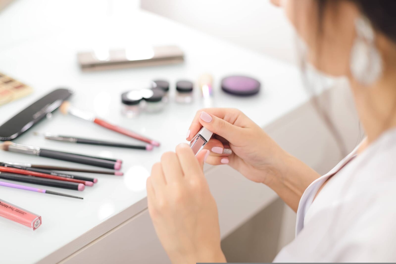 化粧品を手に取りメイクをする女性